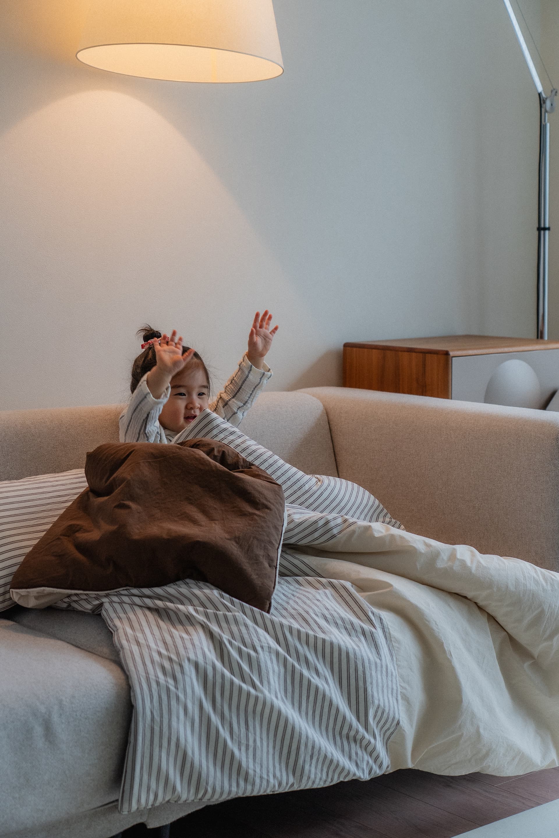 Joyful toddler sitting on a cozy neutral couch
